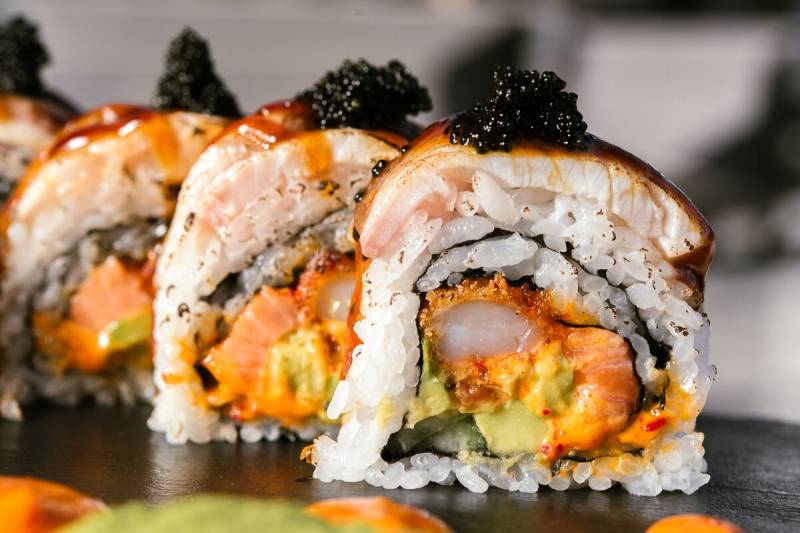 Tempura sushi rolls displayed with black fish eggs on top