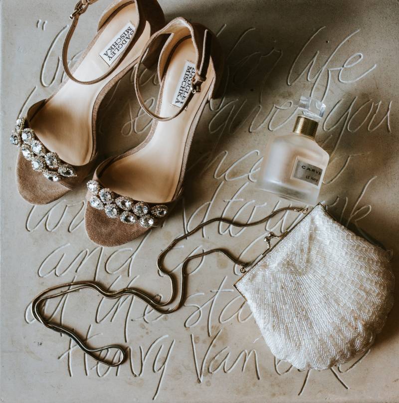 Brown open toed heels and clutch flat lay on suede background