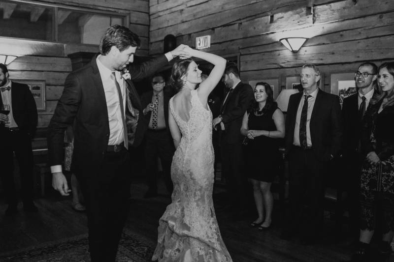 Black and white Bride and groom dancing in white lace open back dress
