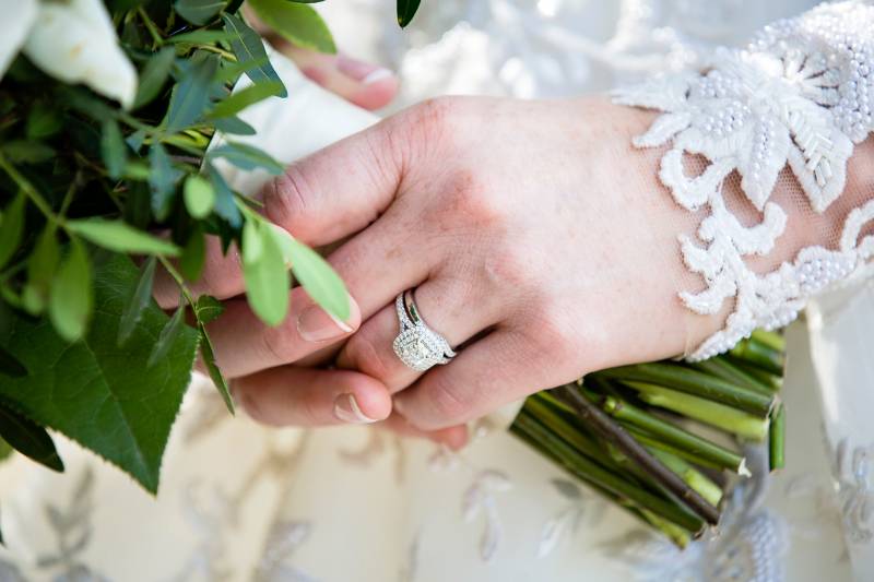 Close  up of brides wedding ring holding bouquet 