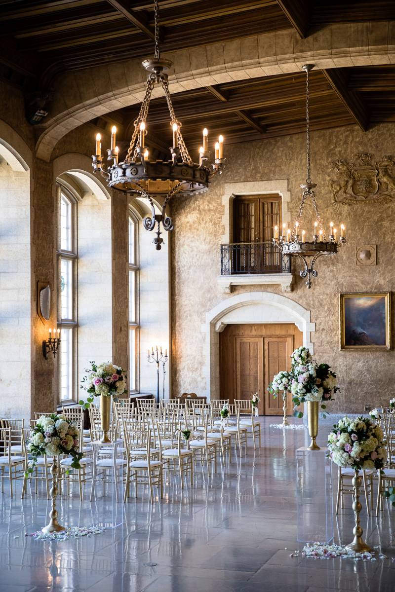 Large open room with hanging chandeliers and golden frame seats in rows  