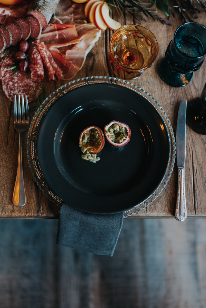 Place setting on black plate with meat charcuterie 