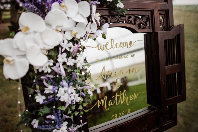 Mirrored Wedding sign with white orchids and lavender bouquet