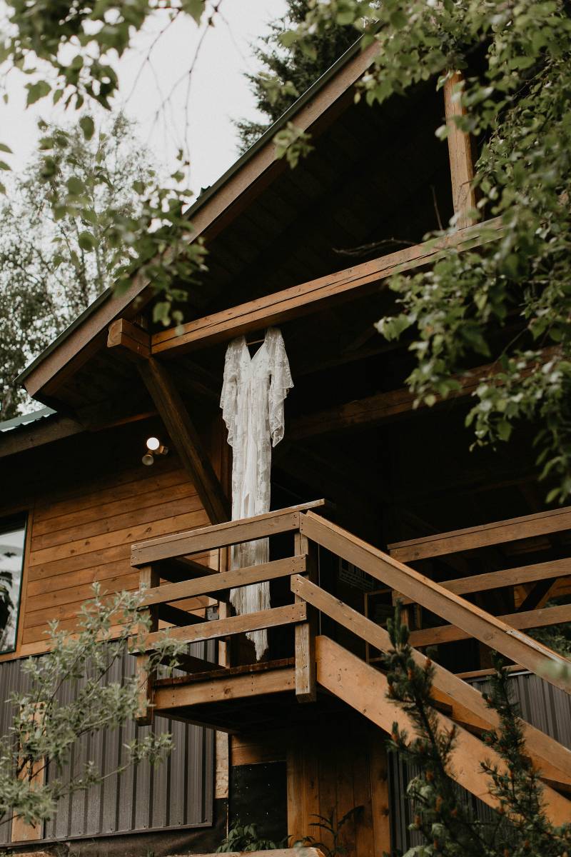 White wedding dress with lace hanging off porch beam 
