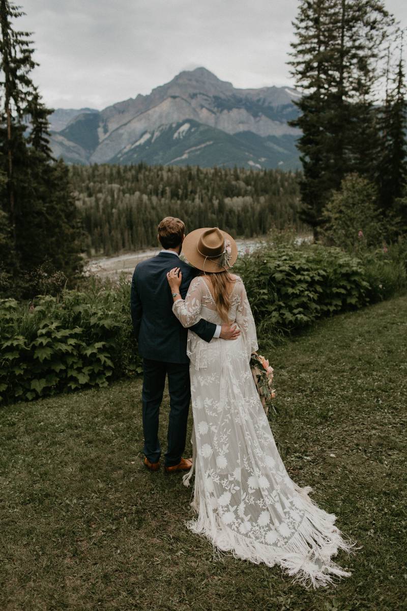 Bride and groom with white lace bodice dress with macramé and brown suede hat 