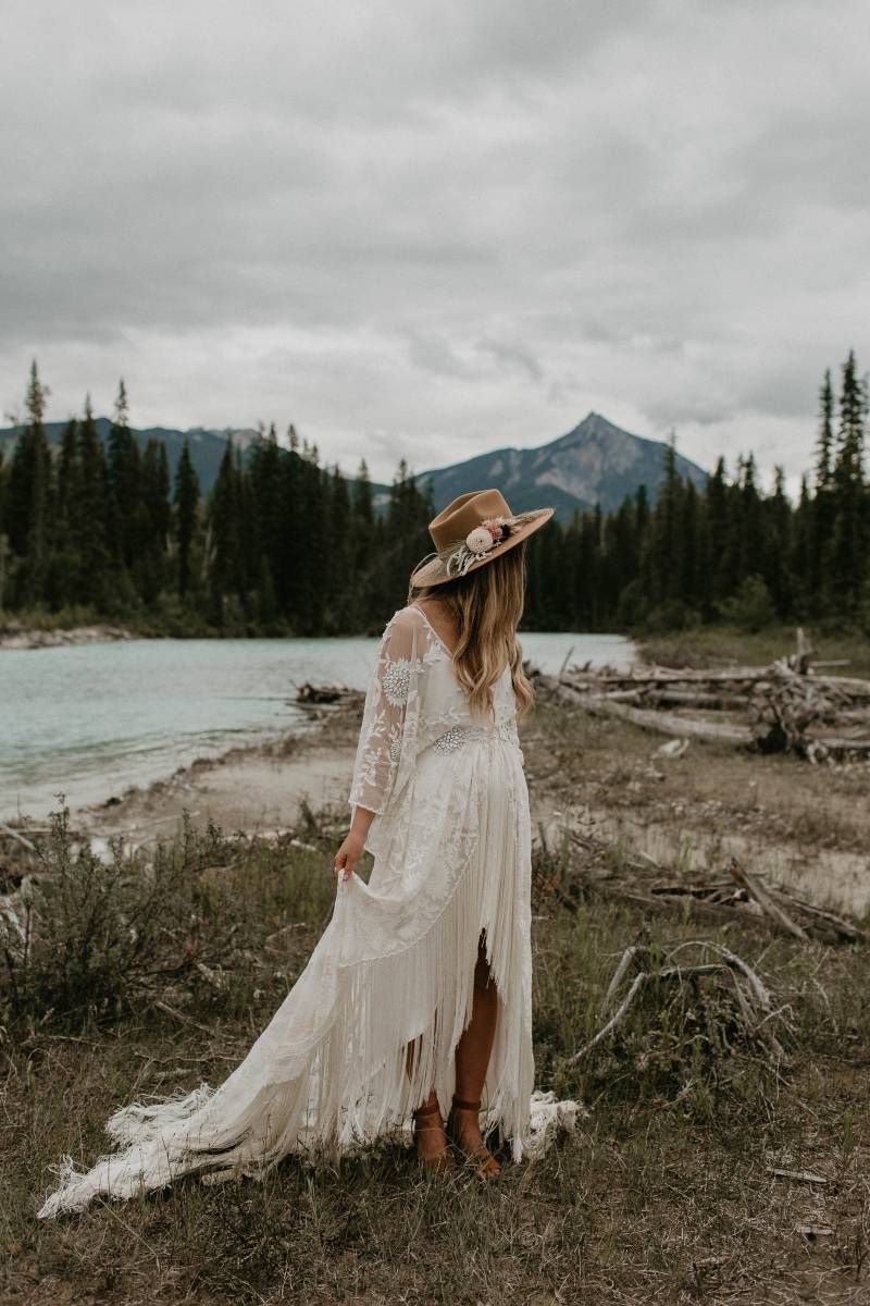 Bride with macramé dress and lace bodice and brown suede hat 