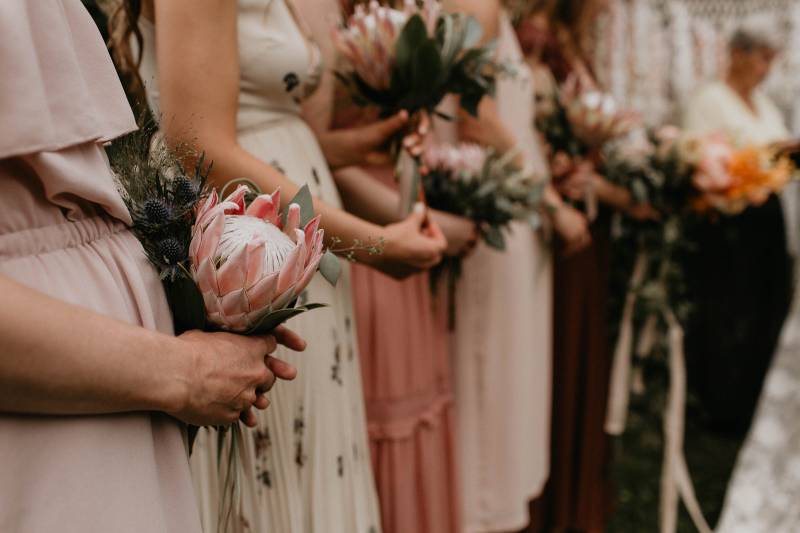 Blush and cream dressed bridesmaids with blush bouquets in line 