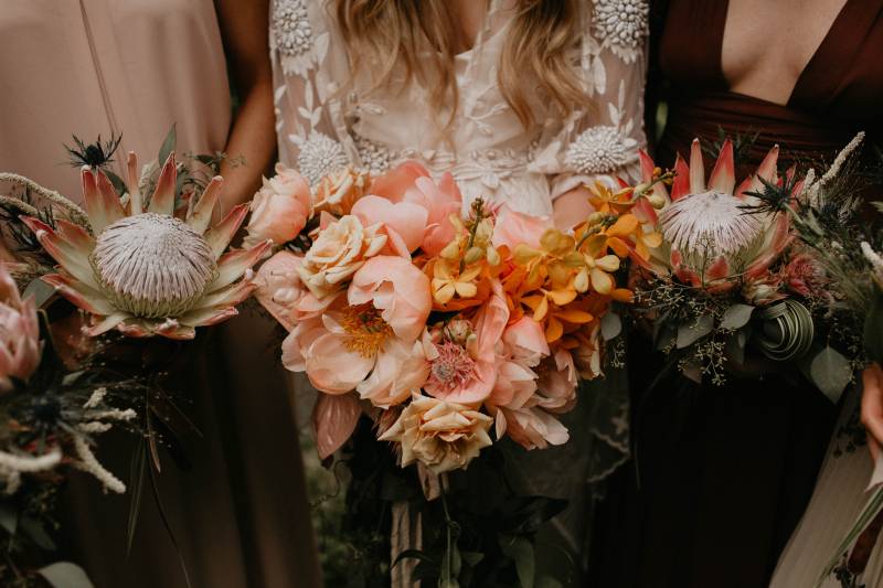 Bridesmaids holding blush bouquets and lace bodice dresses