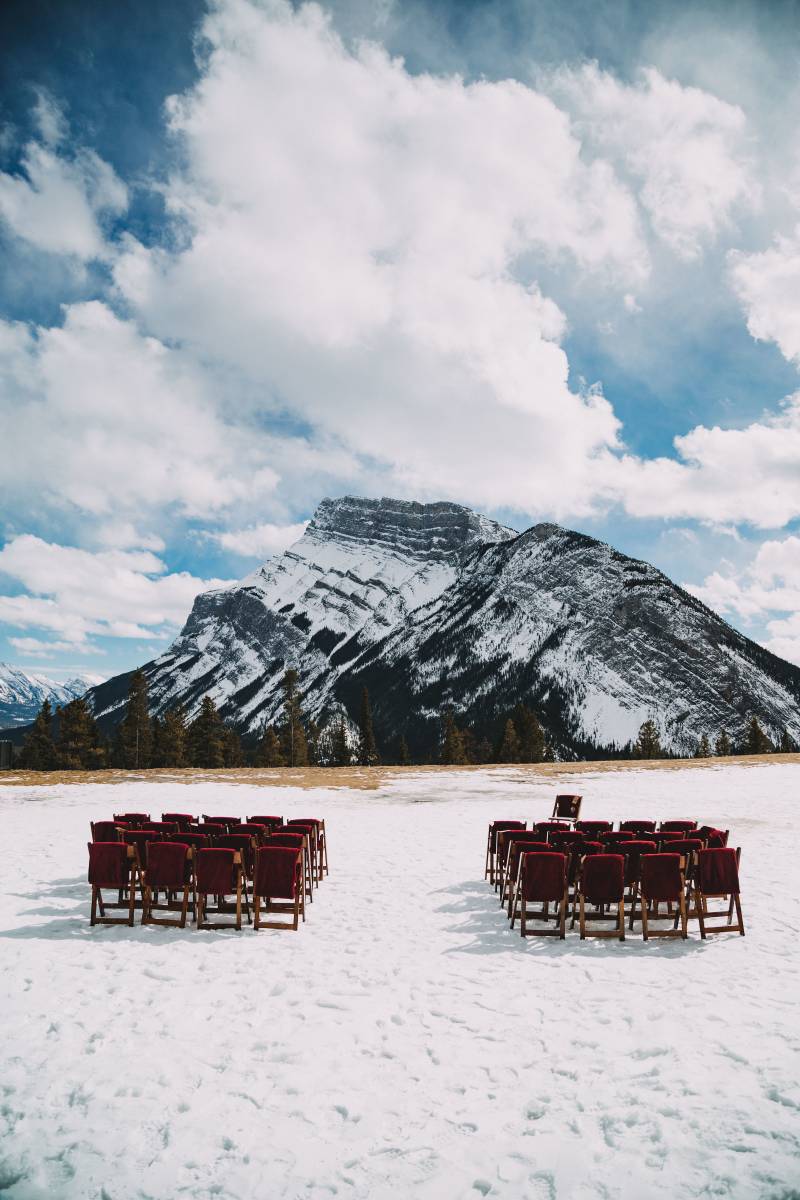 Large snowy field set with chairs facing large snowy mountain