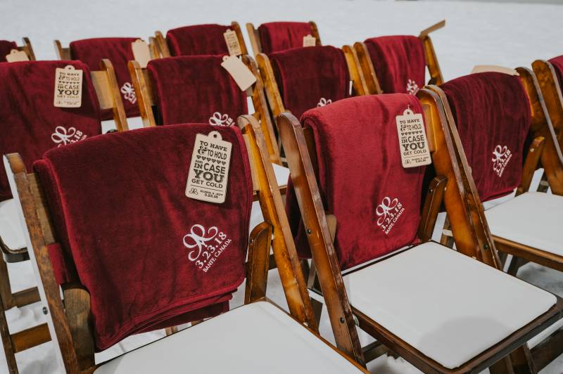 Wooden seats with personal red blankets draped over the back