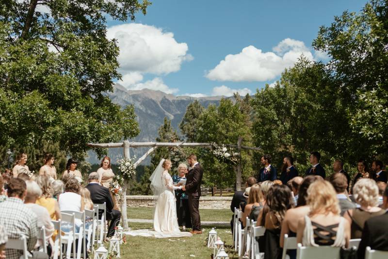Wedding ceremony with mountain backdrop and rustic wooden wedding arch 