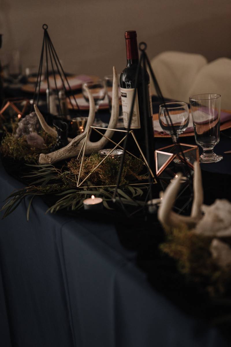 Black table with gold geometric centerpiece and animal horns 