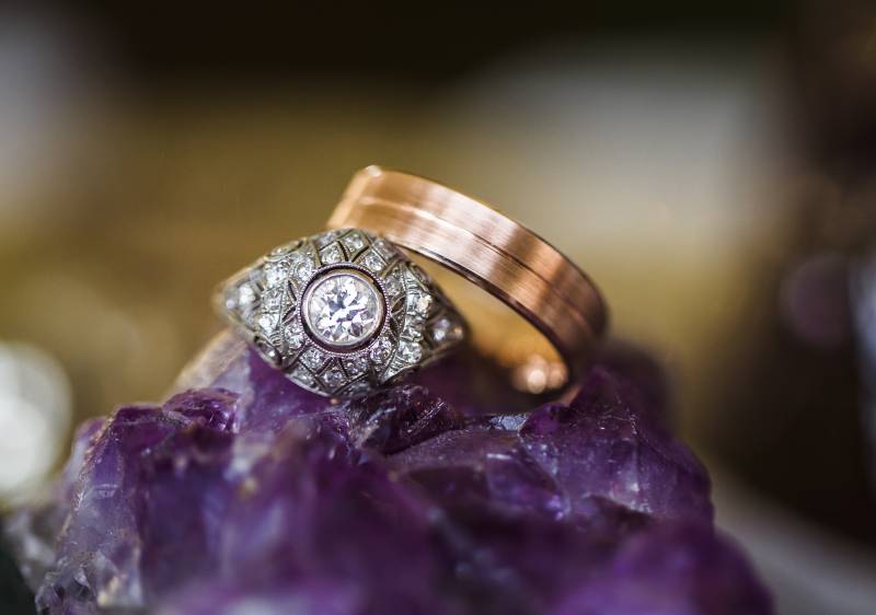 Bride and groom rings stacked on purple geode 