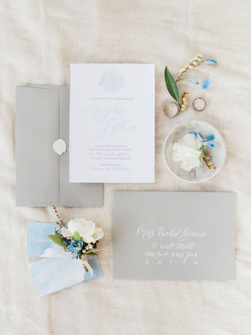 Dusty blue wedding invitation with grey envelope  and engagement rings 