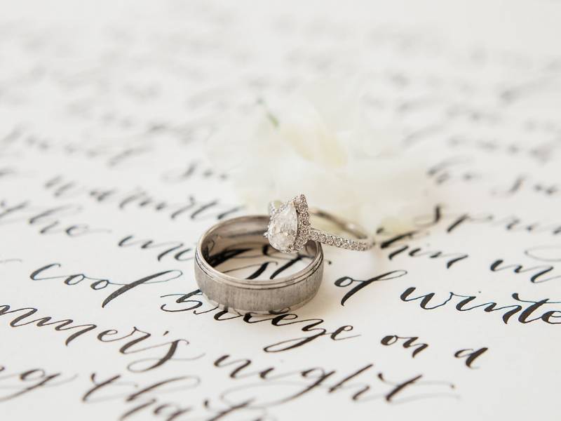 Engagement rings stacked on page with black cursive writing