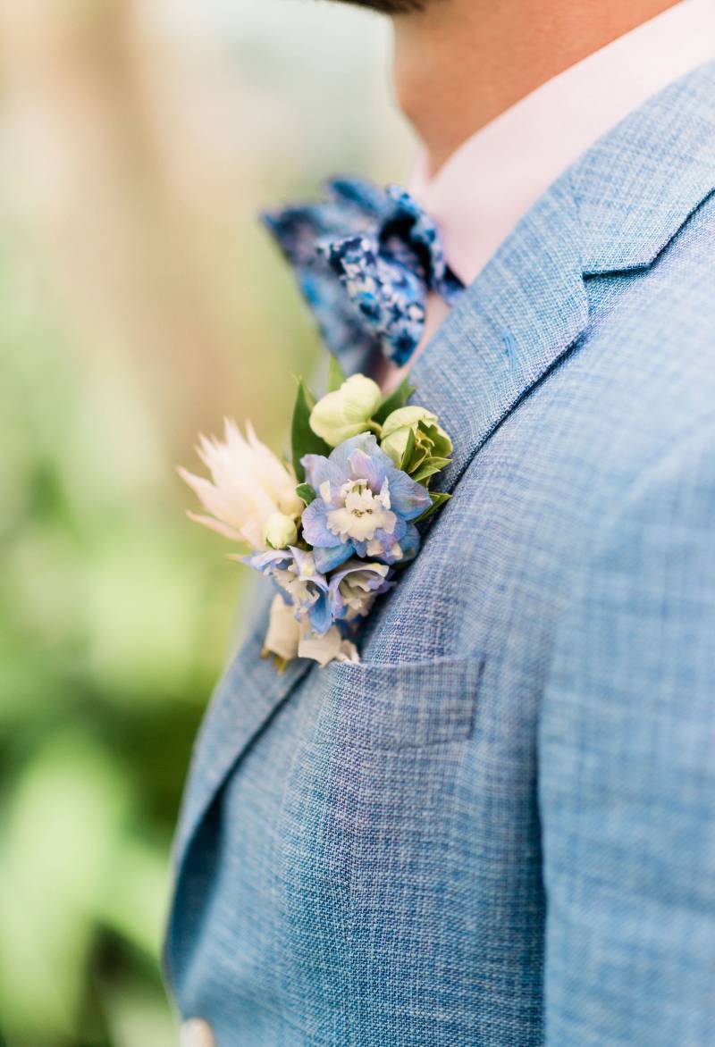 White and light blue boutonniere on light blue suit jacket  