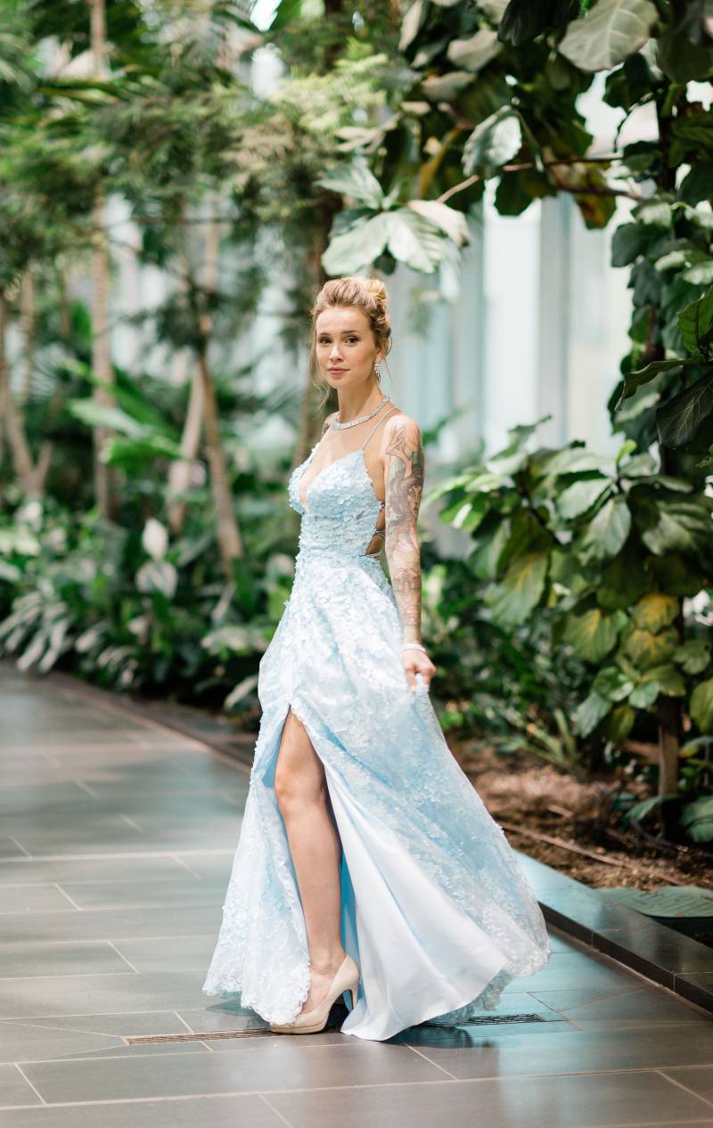Woman in baby blue lace dress standing in atrium