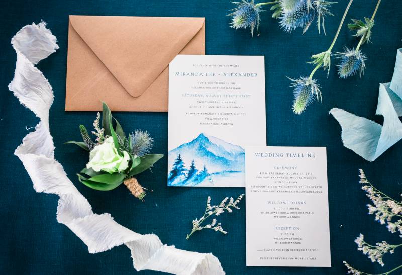 Wedding invitation flat lay with lime green boutonniere and white and blue ribbons  