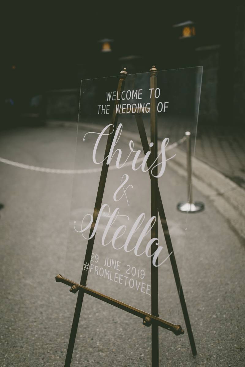 Glass wedding sign with white lettering on black easel 