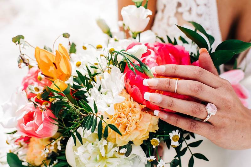 Pink white and yellow flowers with woman's hand caressing  