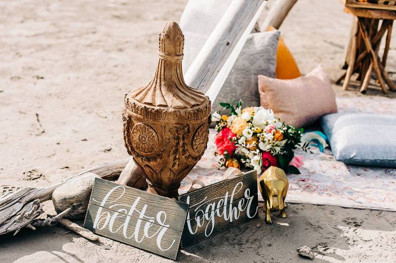 Small wooden signs beside wooden vase and flowers 