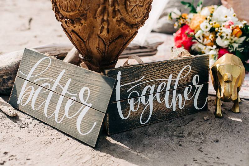 Small wooden signs beside wooden vase and flowers 