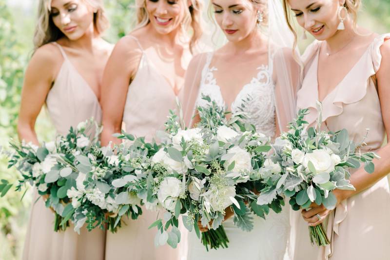 Bride and bridesmaids holding white bouquets 