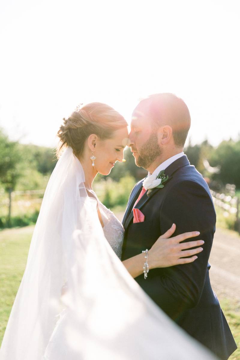 Bride and groom embrace smiling veil flowing 