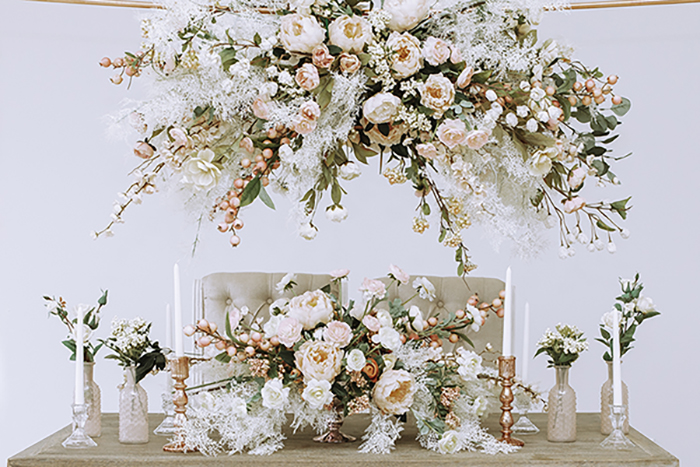 Large hanging floral arrangement over table with large blush centerpiece and candlesticks