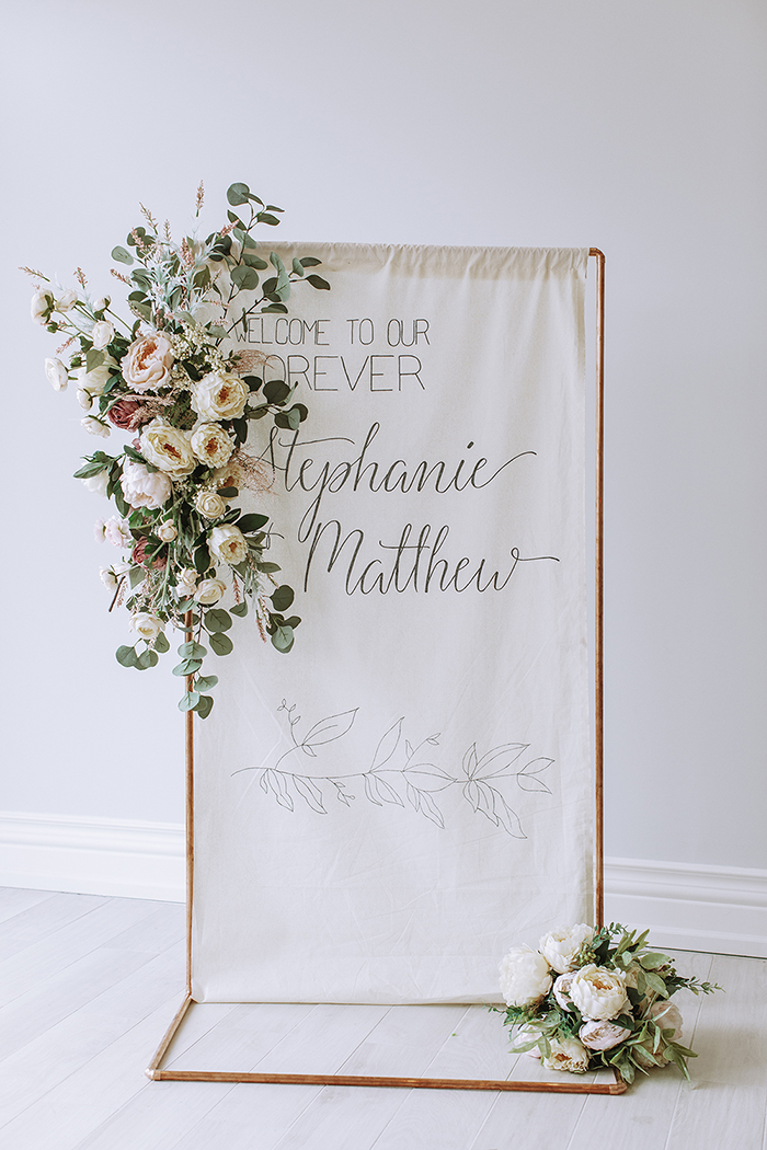 Wedding sign with copper tube and blush and white floral accents 