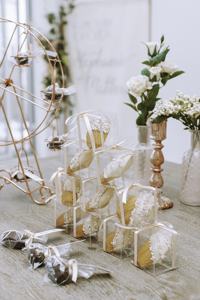 Cakes in clear boxes stacked in a pyramid with blush ribbons