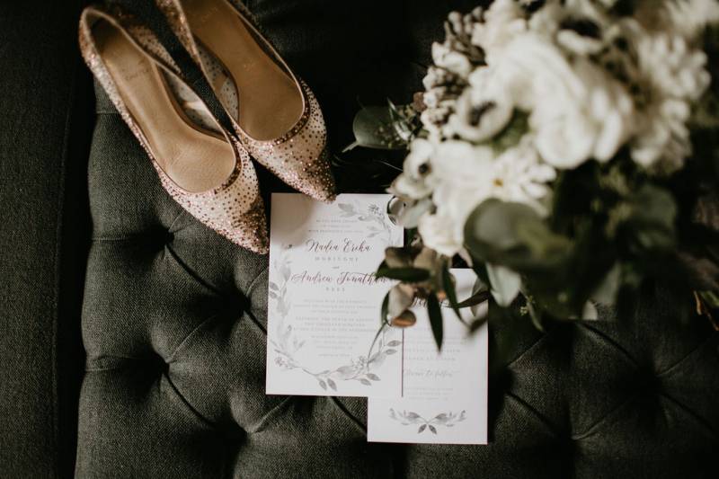 Wedding invitation flat lay with sparkling heels and white bouquet 