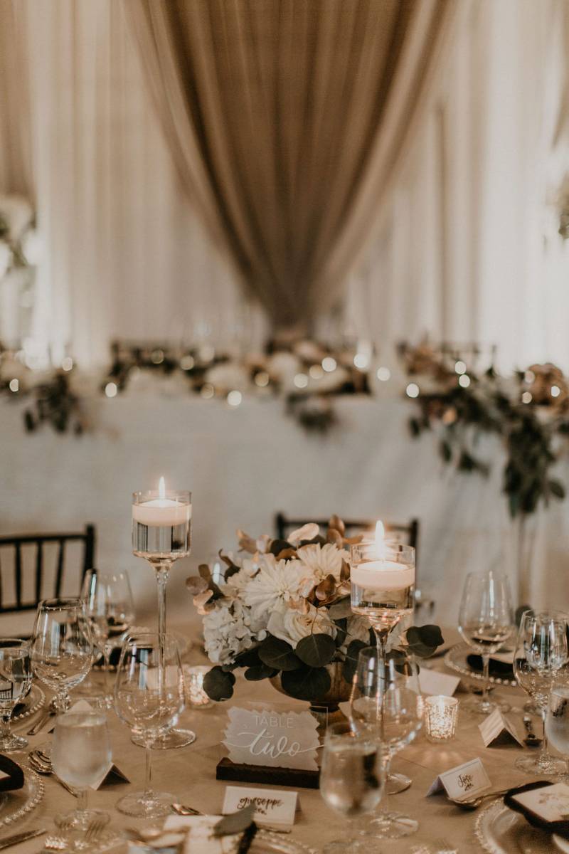 candlelit place setting with white floral centerpiece 