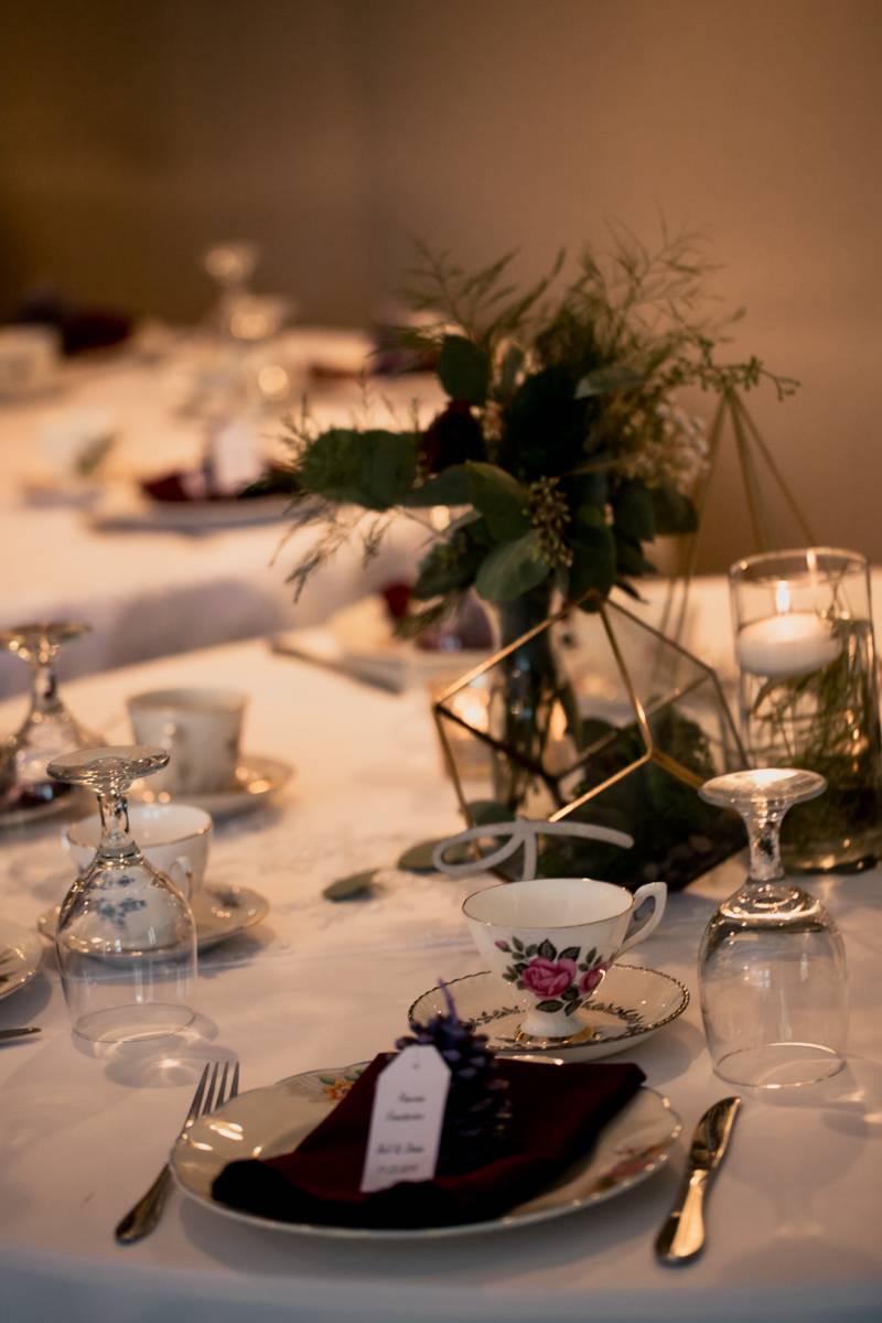 Table scape with glass and gold centerpiece and tea cups 