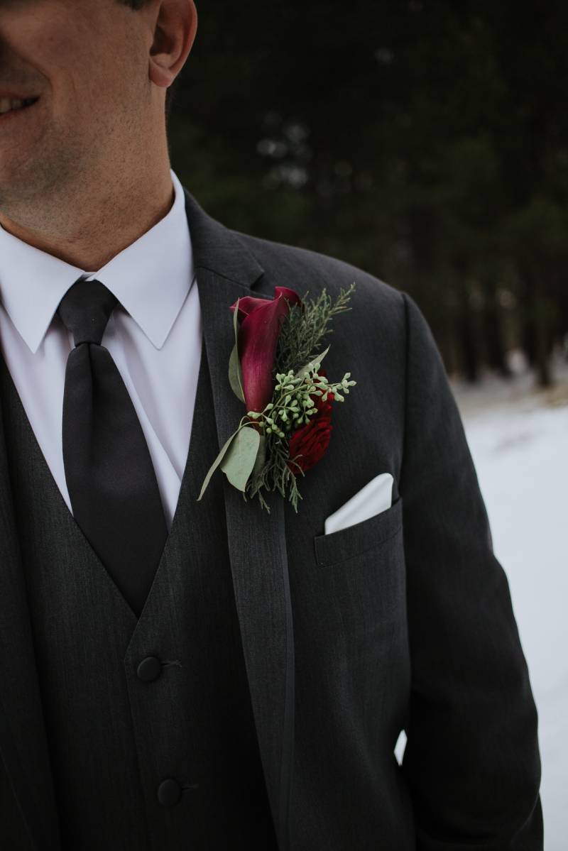 Burgundy boutonniere on groom in black grey suit  
