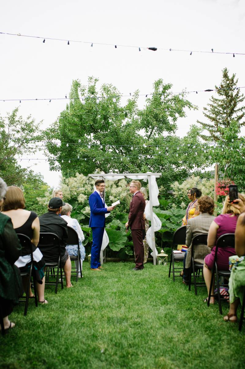 Grooms saying their vows at a garden wedding
