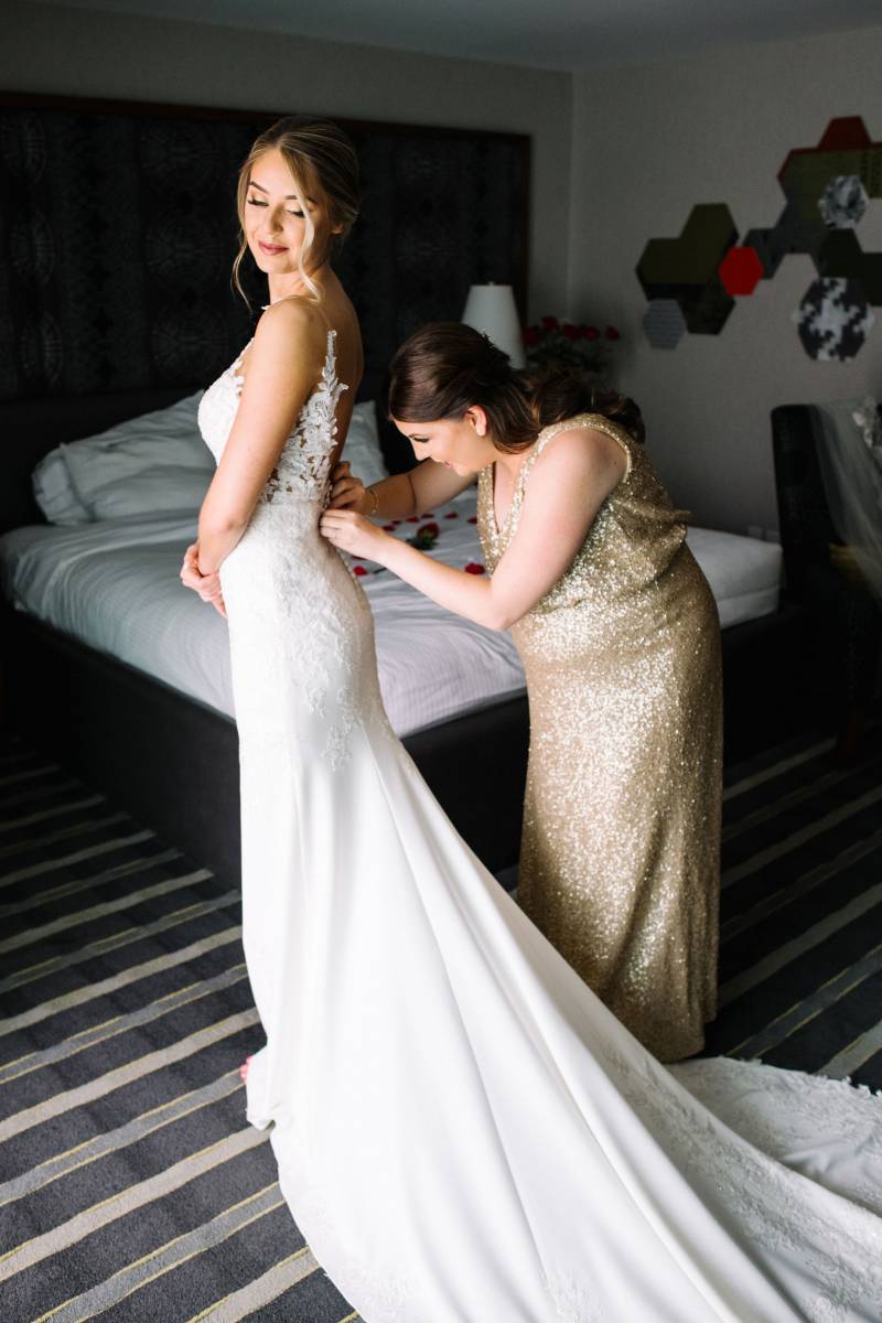 Adjusting Bride wearing white lace bodice and long white skirt