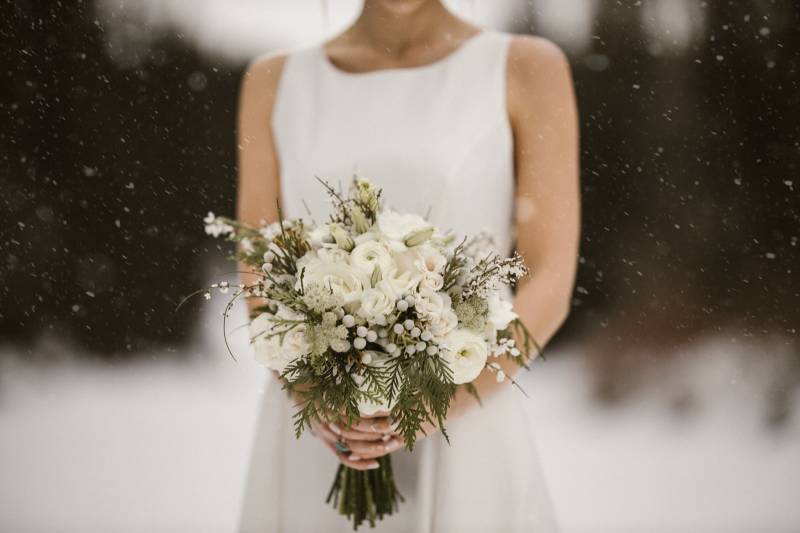Bride in white dress holding white bouquet 
