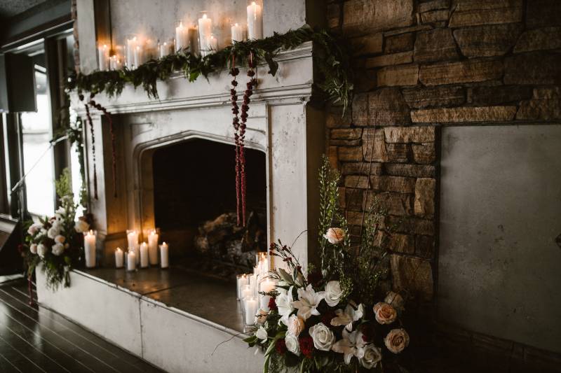 Candles and white bouquets placed on old white fireplace and mantle 