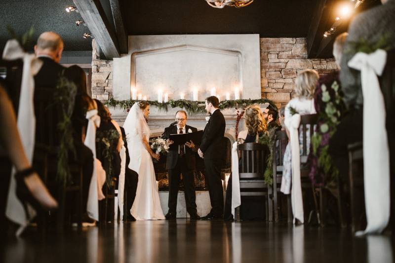 Officiant reads while bride and groom stand apart and audience watches 