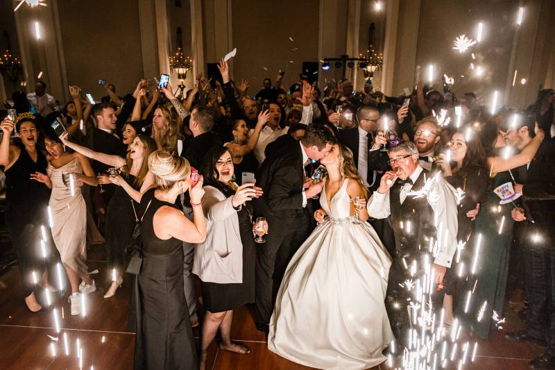 Wedding reception bride and groom kissing white sparks fly around 