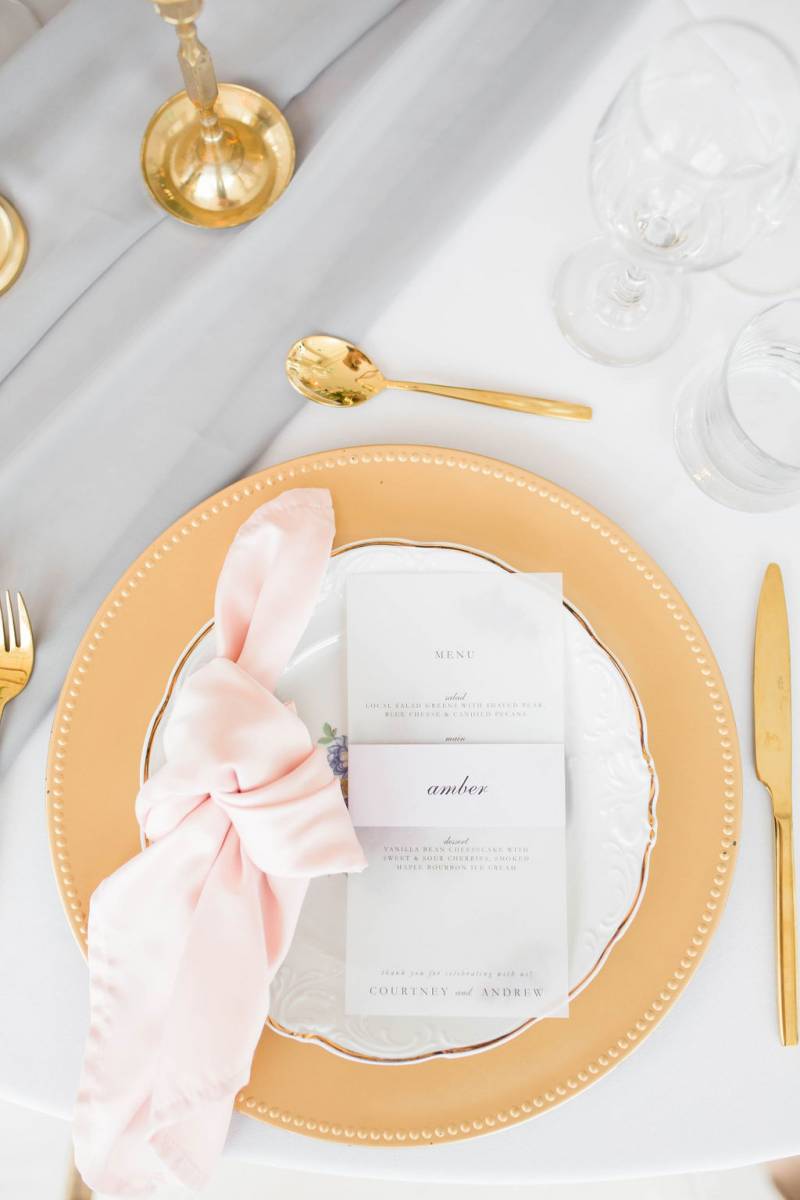 Table setting flat lay with gold cutlery and blush napkin