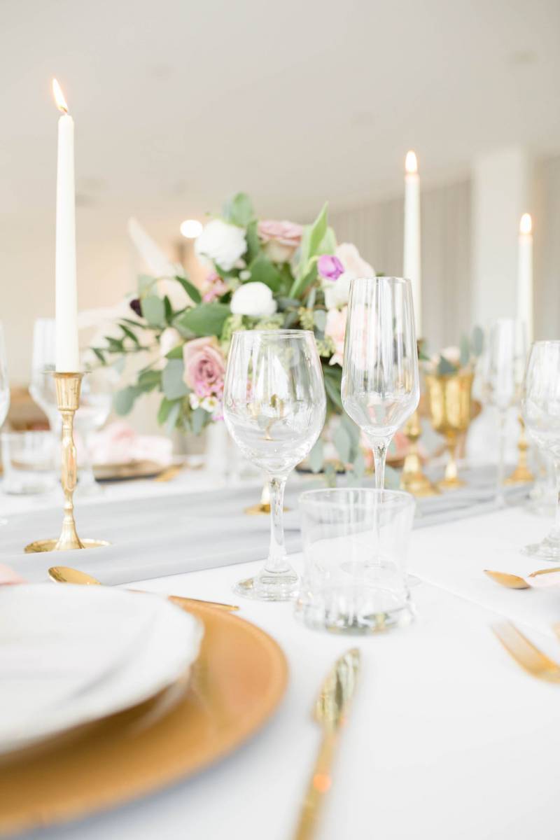 Table setting with gold accents and purple and white centerpiece