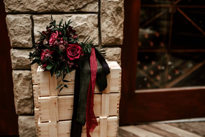 Red flowers and red and green ribbons on top of three wooden boxes 