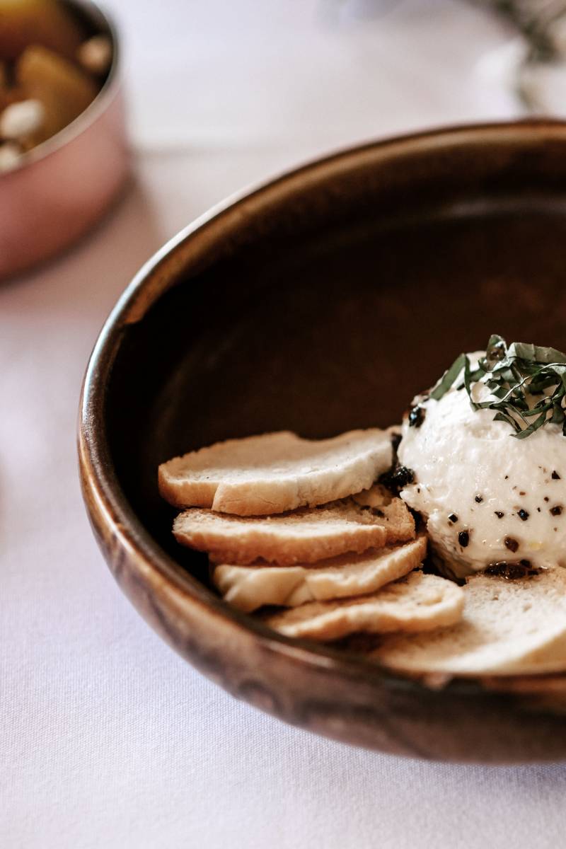 Small wooden bowl with bread crackers and cheese with herbs 