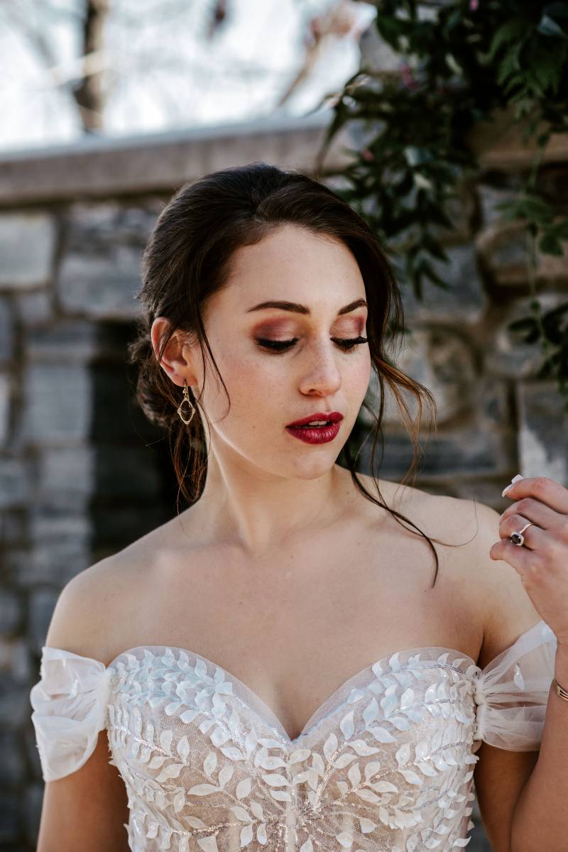 Woman in white lace dress looks down 