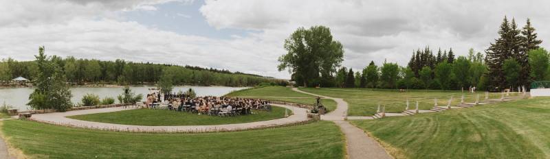 Panoramic shot of wedding ceremony in front of river  with guests seated