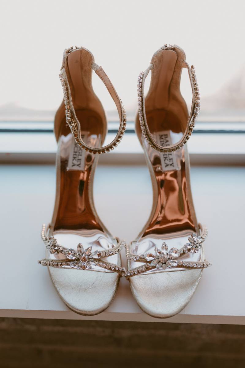 Open toed heels with bronze insoles and jewels on straps on windowsill 