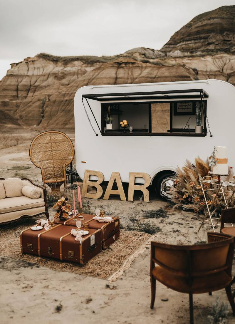 mobile white food truck parked behind small coffee nook in desert 