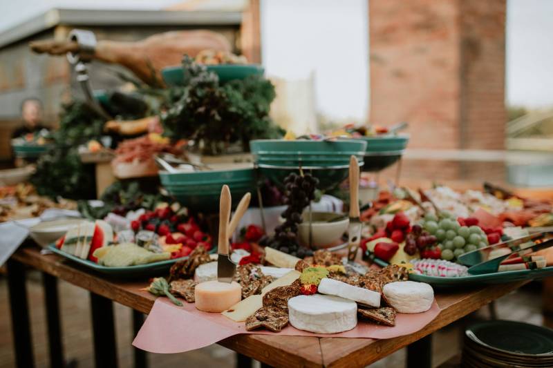 Cheese Charcutier board on outdoor table with fruit and knives